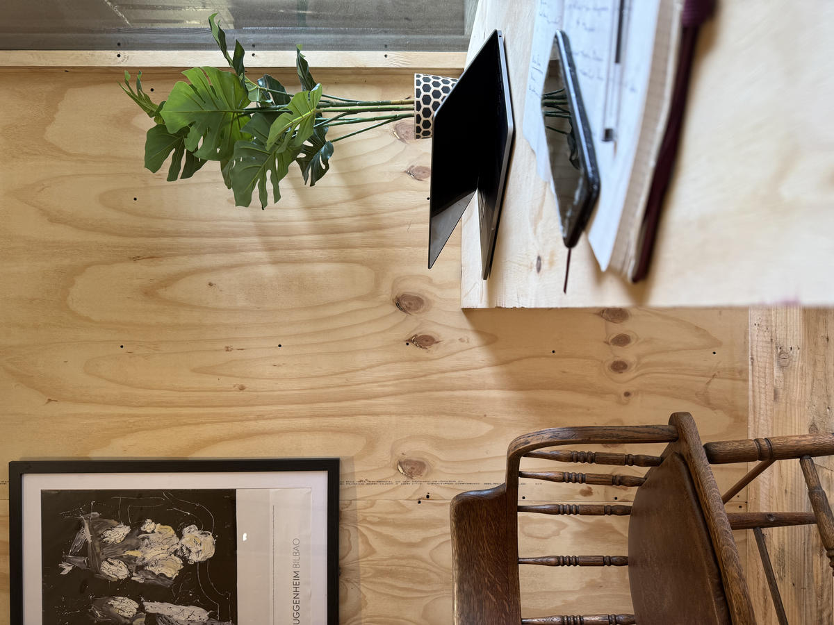 Corva interior — desk and workspace with birch ply walls and Guggenheim Bilbao print